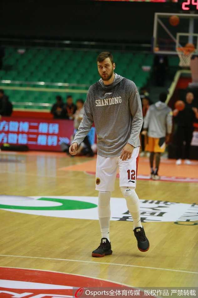 丁彦雨航单手投篮后故意保持僵硬的落地姿势，如同机器人一般，站在旁边的教练看到这一幕也无奈地摇头笑了
