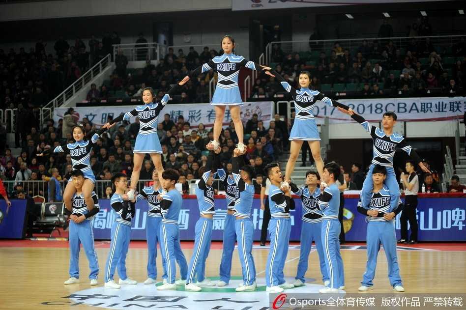 底层宝贝咬紧牙关，额头渗出汗水，双手紧紧抓住上层同伴的小腿，肌肉线条在灯光下清晰可见，用身体撑起整个团队的荣耀