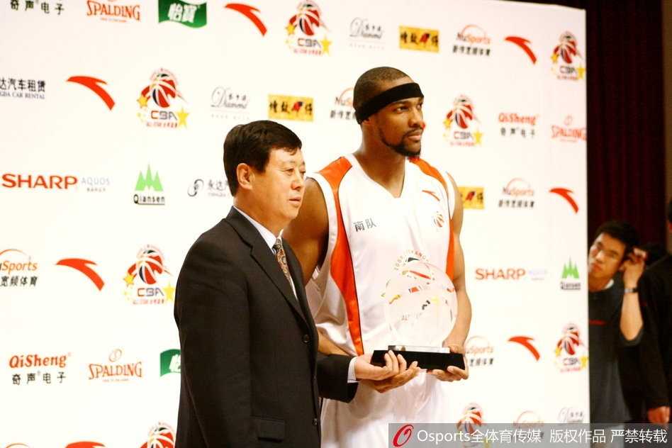 王治郅再次捧起MVP奖杯，面露温润笑容，身后是南区的队友们为他鼓掌。