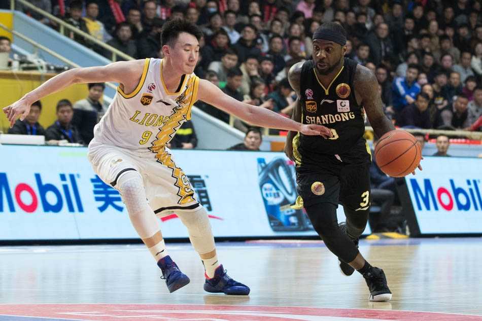 胡金秋在山东队内线群中高高跃起，犹如鹤立鸡群，稳稳摘下进攻篮板，眼神中充满了对胜利的渴望。