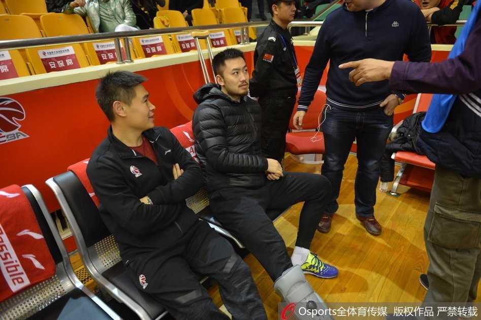带伤观战神情凝重 睢冉缺阵山东加时险胜广厦 睢冉身穿便服坐在球员替补席上,左脚穿着巨大的保护靴格外显眼,他双手交叉神情专注地看着场内,眼神中透露出焦急与渴望。