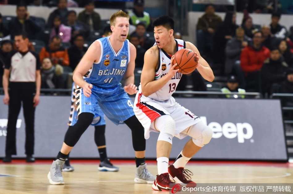 广州队球员在罗旭东命中关键三分后紧紧相拥庆祝，教练席也激动地挥舞着拳头，整个替补区的激情与看台上沸腾的球迷海洋融为一体。