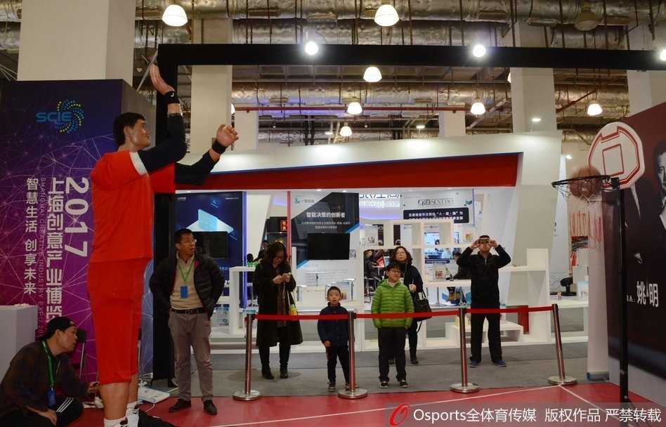 当传奇遇见未来:上海创博会上那座两米二的“投篮巨塔” 在上海创博会的聚光灯下,身高两米二零的‘机器人姚明’静静伫立,其类人的肌肤纹理与深邃的五官,仿佛一位沉默的蓝色巨人凝视着前方。