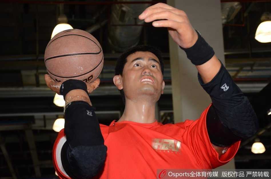 当传奇遇见未来:上海创博会上那座两米二的“投篮巨塔” 工作人员正将手中的篮球递向机器人的右手,它保持着永恒的投篮预备姿势,人与机器的互动瞬间,充满了科技传承的温度。