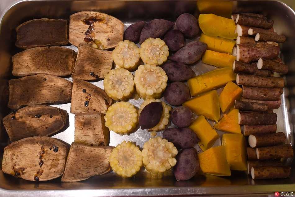 不锈钢餐格里整齐码放着热气腾腾的炖菜和炒菜，营养与美味被巧妙地融合在这看似平常的一盘盘佳肴中。