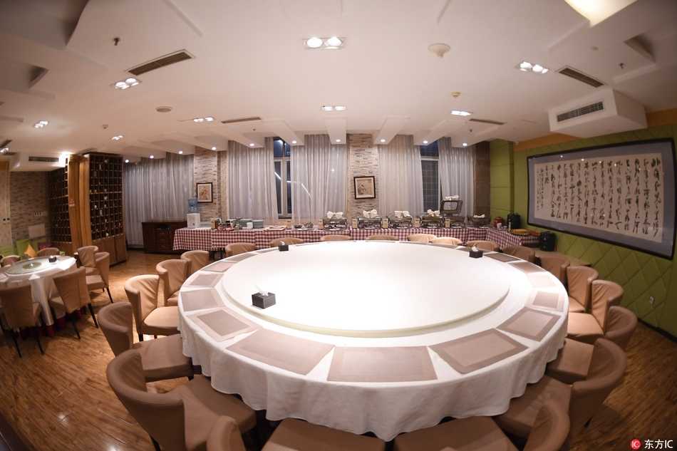 两名身穿白色工作服的服务员面带微笑，随时准备为就餐的球员们提供服务，每一个细节都透露着专业与关怀。