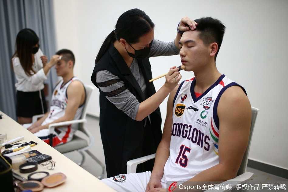 探营广州龙狮新赛季出征 镜头内外尽显岭南雄风 化妆镜前,状元秀陈盈骏正闭眼享受化妆师的精心修饰,平和的面容下,一颗带领球队冲击季后赛的决心早已跳动不已。