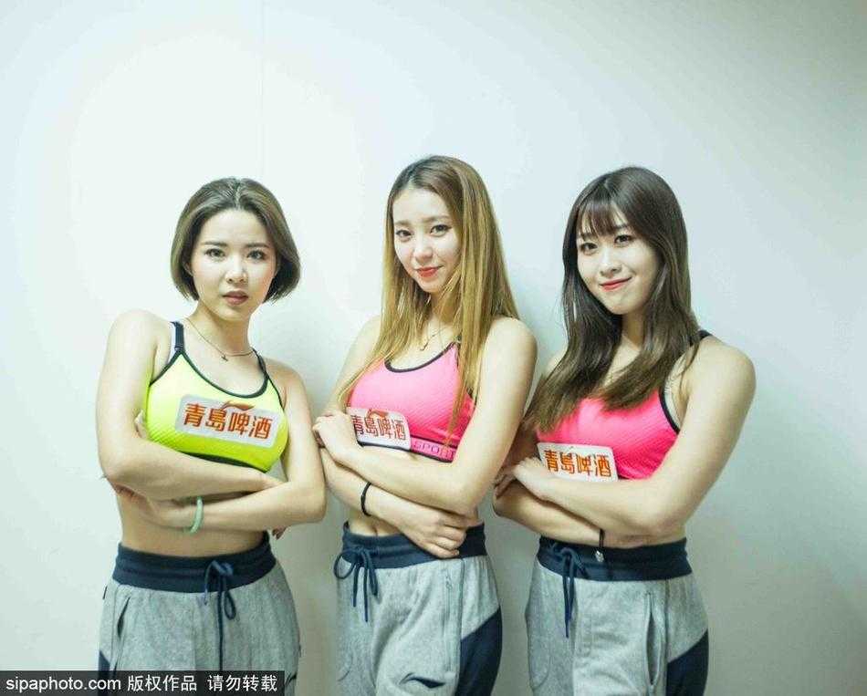 出发前的最后集结，篮球宝贝们将手叠放在一起，齐声高喊加油口号。身后的衣架上挂满了色彩鲜艳的表演服，如同她们即将为赛场涂抹上的亮丽色彩。