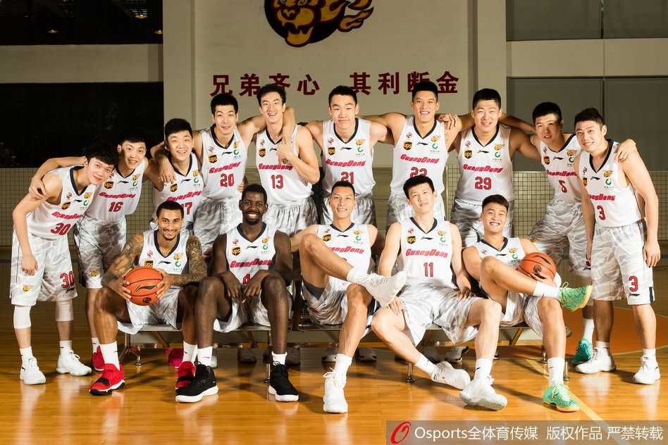 核心易建联在镜头前单手抓球，手臂肌肉线条分明，眼神专注而深邃，仿佛在凝视着新赛季的夺冠目标，静默中透露着领袖的霸气与沉稳。