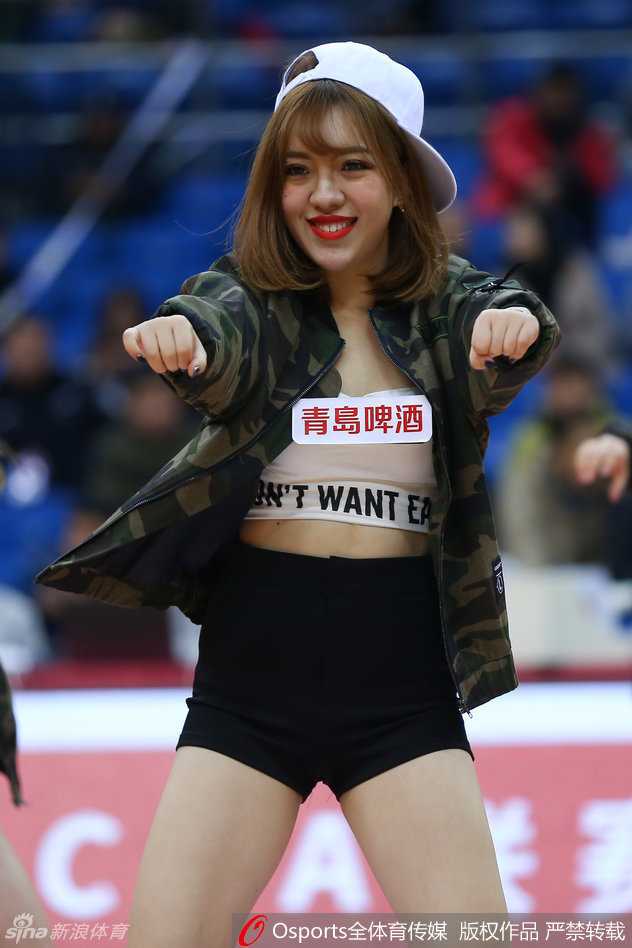 新春首战青岛男篮力克北控 篮球宝贝热舞点燃赛场 表演尾声,宝贝们摆出结束造型,身后的球迷看台虚化成斑斓的光点,共同构成了一幅生动的赛场庆祝画面。