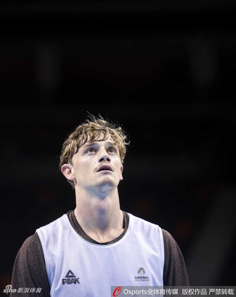 训练结束后，球员们在场边进行拉伸放松，助理教练正在帮助一名队员进行肌肉放松，氛围轻松融洽。