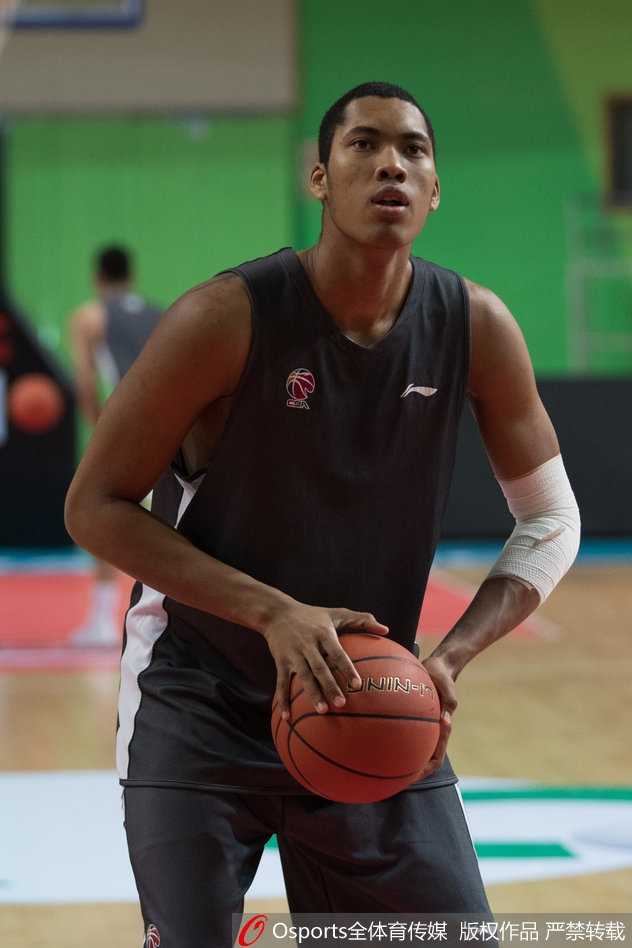 主教练雅尼斯在训练间隙，用手势比划着向队员们讲解战术跑位的细节