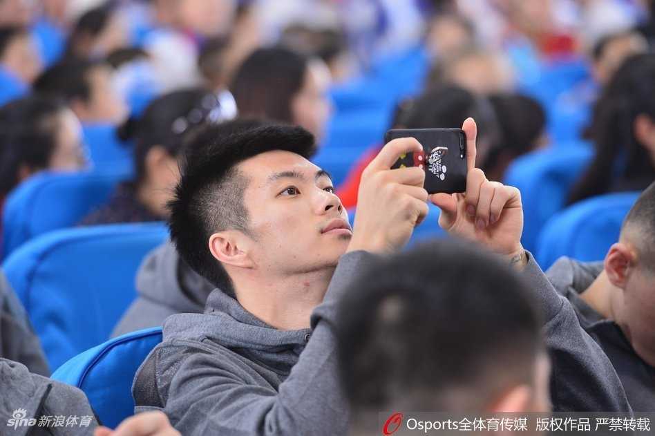 孩子们为球员们送上亲手制作的小玩偶作为礼物，一位球员蹲下身子，双手接过礼物，脸上洋溢着惊喜与感动的笑容。孩子虽然听不见，但眼中闪烁着羞涩又幸福的光芒。