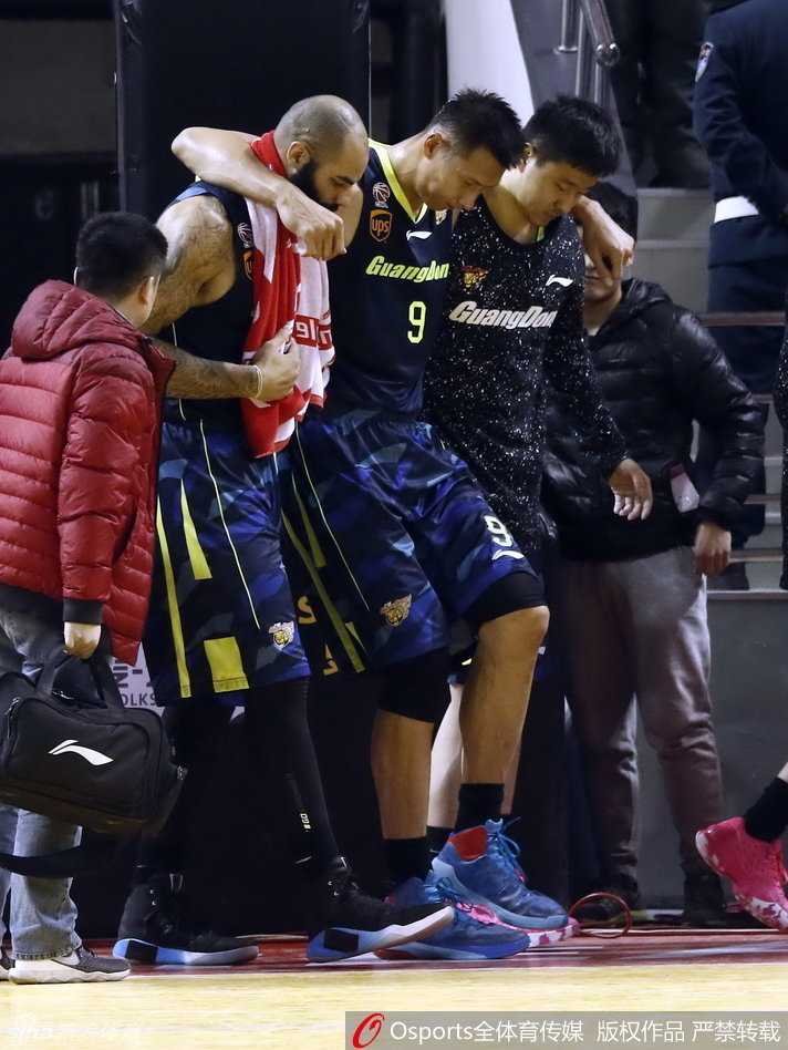 易建联膝盖重伤离场 广东17连胜之夜蒙阴影 易建联在两名队友的全力搀扶下离场,他全身重量几乎都压在队友身上,低垂着头,步伐蹒跚地离开赛场