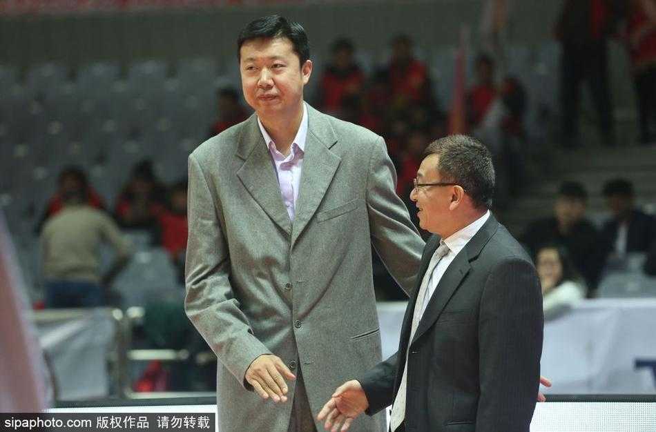 王治郅的表情柔和，凝视着眼前的范斌，眼神中既有对往昔并肩作战岁月的怀念，也有对眼前这位老友如今在教练岗位上辛勤付出的敬意。他的姿态沉稳，八一队深厚的底蕴仿佛就刻在他的举手投足之间。