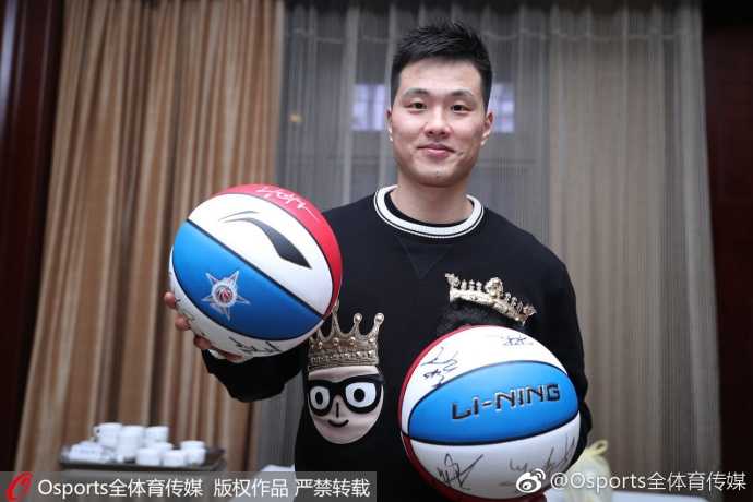 南区全明星的易建联与周鹏被热情的球迷簇拥，他们面前的篮球已堆积如山。阿联神情专注，在一颗颗篮球上签下名字，虽然表情严肃，但动作中透露出对后辈球迷的无限宠溺。