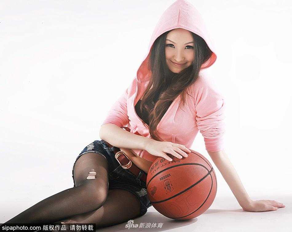 杨乃霏篮球宝贝丝袜美腿写真 运动场上的甜美风暴 杨乃霏侧身倚靠在篮球架旁,轻轻撩动秀发,宽松的运动背心下摆微扬,不经意间展露被丝袜包裹的修长美腿,姿态既俏皮又充满魅力。