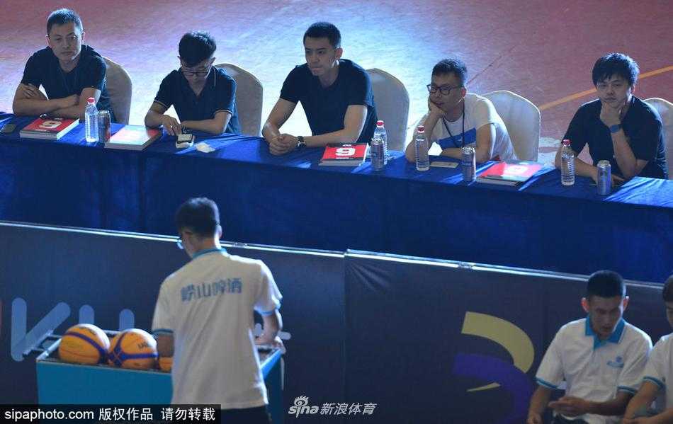 杨鸣现身沈阳三对三赛场 帅气依旧畅谈全运新目标 杨鸣坐在评委席上,手拿打分表,神情专注而认真。他身后的背景是热闹的三人篮球赛场,彩旗飘扬,而他仿佛隔绝了周围的喧嚣,沉浸在专业的评判之中。