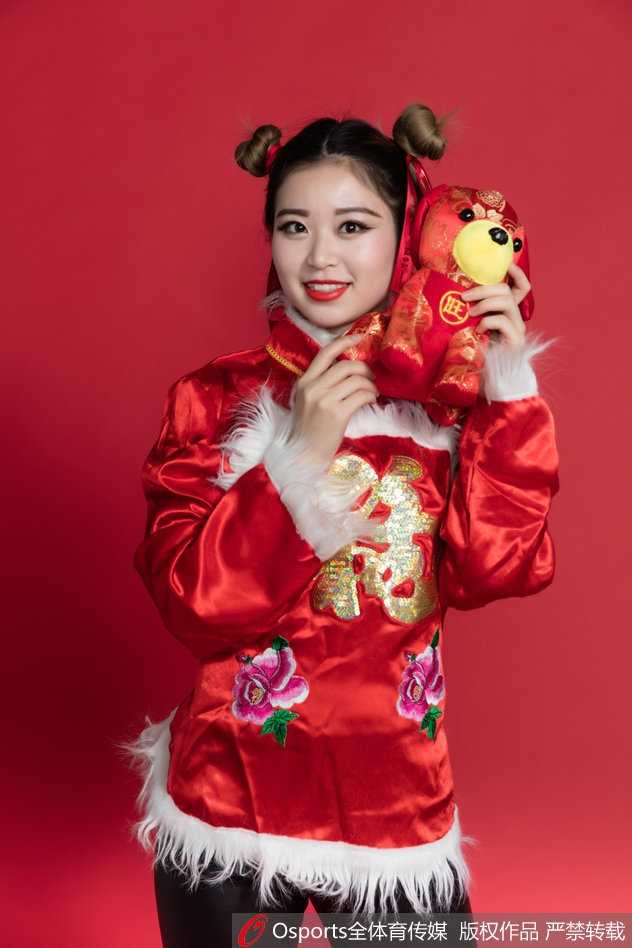 民俗霓裳舞新春 篮球宝贝赛场绽放中国风 宝贝轻抚发髻,一身明艳民俗装束在红色背景衬托下更显喜庆,眉眼间流露的娇俏与温柔,恰似新春最美好的祝福。