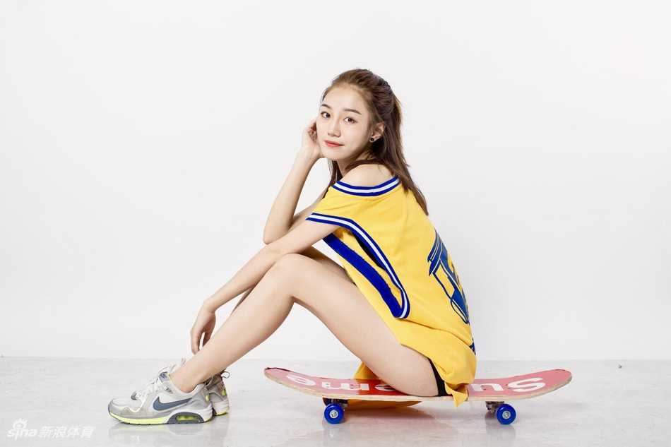 江慧身穿23号球衣，脚踩滑板回头一笑，球衣下摆随着动作轻轻飘起，满满的运动元气