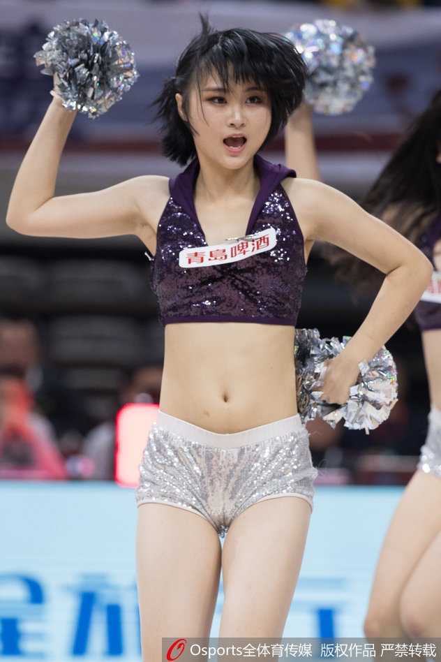 浙厦之争的激情点缀 篮球宝贝舞动主场光芒 灯光聚焦于舞台中央,领舞的宝贝高举双手,带领身后的团队共同演绎一段高潮舞步,她们身后的巨幅海报映衬出浓烈的比赛氛围。
