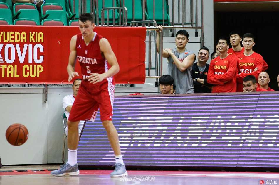 深圳夏夜的双雄会:斯坦科维奇杯德国战车碾过克罗地亚狂想曲,中国队静默观战 镜头拉近,中国男篮的一位球员眼神专注,嘴唇微张,似乎完全沉浸在了比赛的节奏里。背景是模糊的看台观众,他的脸上还带着些许属于年轻人的稚气,但在那一刻的凝视中,透露出的是超越年龄的沉稳。仿佛正在心中默默模拟,如果换做是自己,该如何应对眼前这激烈的欧洲对抗。