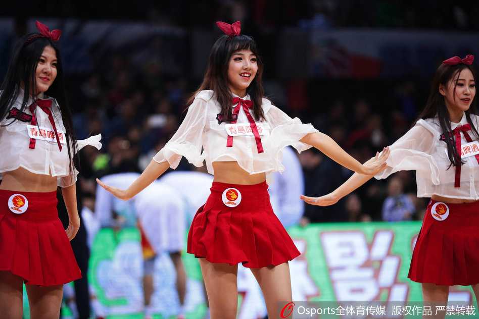 深圳篮球宝贝烈焰红裙舞动赛场 助力新世纪大胜青岛双星 深圳篮球宝贝近景,精致的妆容在汗水映衬下更显光彩照人,她手拿金色花球,面带极具感染力的微笑,专注地进行着表演。