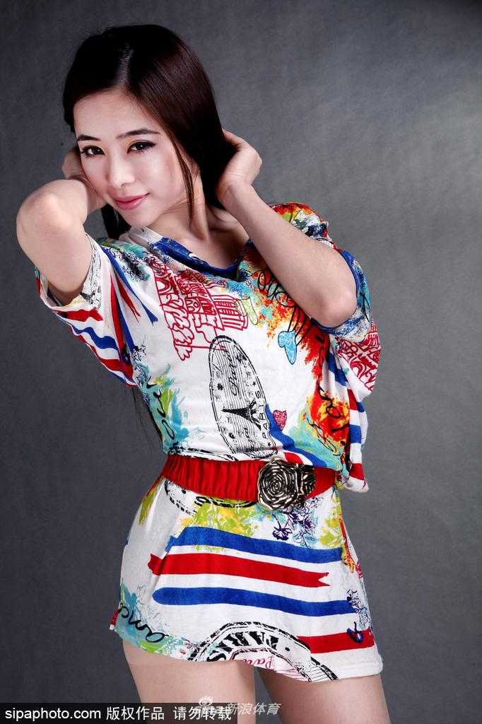 光线透过铁丝网洒在袁颖芬身上，她单手扶着围网，神情淡然却气场十足，完美融合了力量与柔美