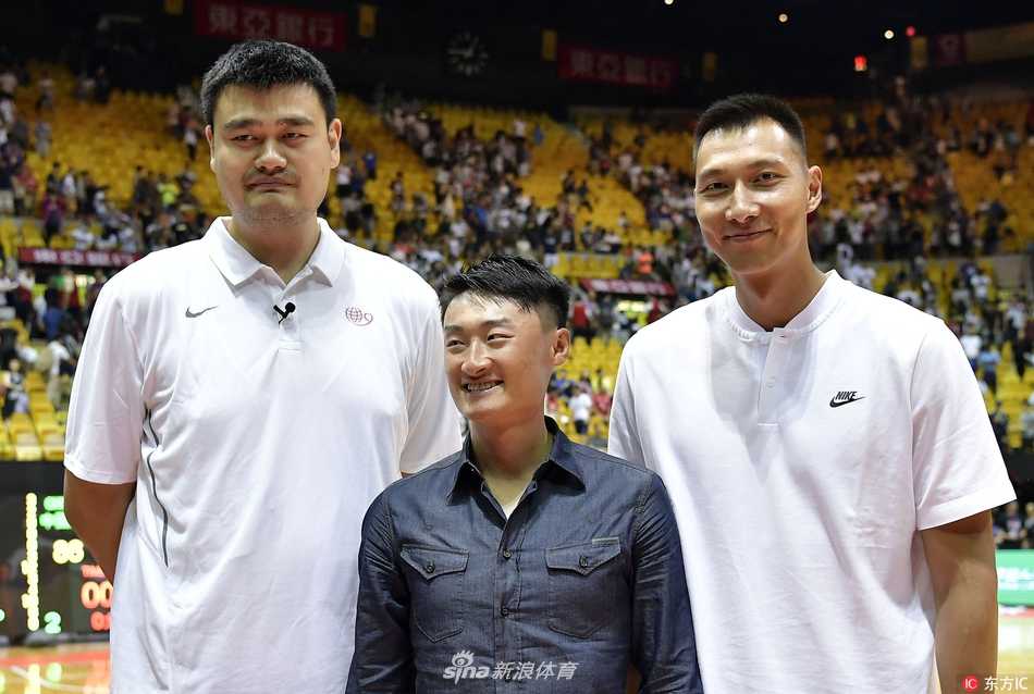 温情对决燃动香江:易建联场边助阵,姚明卡特老友记闪耀姚基金慈善赛 姚明与卡特面对面站着,两人脸上都洋溢着老友重逢的灿烂笑容,卡特用手指着自己下巴的胡须,似乎在与姚明分享着关于时光的趣事,身后喧嚣的球场成了他们叙旧的温馨背景。