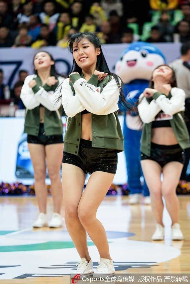 热力绽放与绝杀时刻:回顾川军主场那些耀眼的篮球宝贝 纵排构图下,一名篮球宝贝背对镜头,但依然能感受到她随着节奏扭动的身姿,华丽的服饰下摆飞扬,场边的广告牌和观众席虚化成背景。