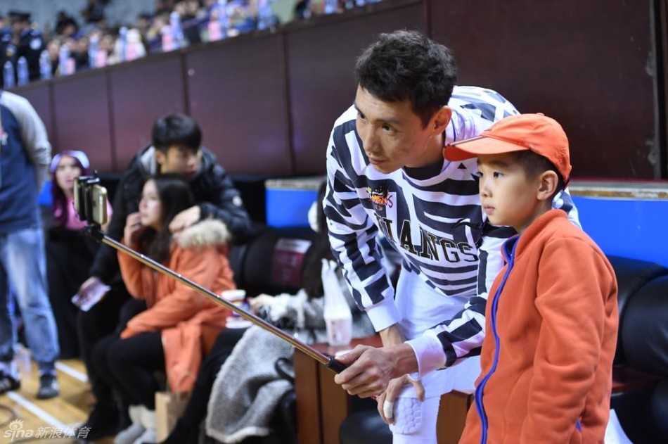 热血汇聚五台山,爱心温暖小轩轩 球场的绝佳观赛席位上,小轩轩在父母的陪伴下专注地观看比赛,脸上洋溢着纯真而开心的笑容,完全沉浸在篮球的快乐中。