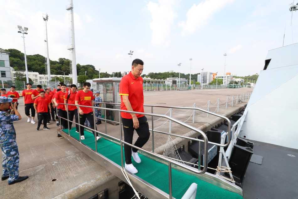 在热烈的掌声中，中国男篮红队副领队毛永强与驻港部队官兵代表交换象征荣誉与友谊的队旗，两支队伍的手紧紧握在一起，定格下军民团结的动人画面。