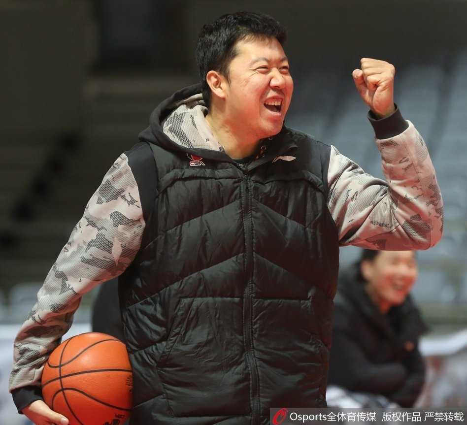 训练间隙，王治郅将队员们召集在一起，拿着战术板讲解跑位战术。