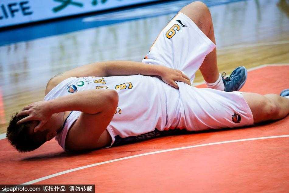 徐煜峰在防守对抗中突然遭到撞击，面部表情瞬间扭曲，身体失去平衡向地面倒去。