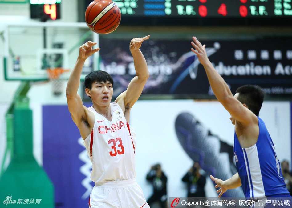 内线巨塔韩德君在三人包夹夹缝中奋力跃起，用一双巨大的手掌牢牢控制住篮板球，展现了他在禁区内的绝对统治力。