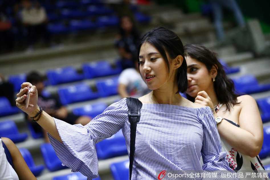 萌娃趴在栏杆上，专注地看着场内，为男篮加油，眼神里充满童真与热情