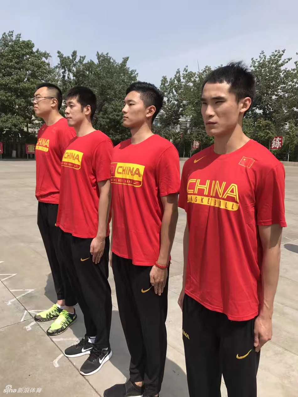 教官正在纠正队员的动作，刚毅的目光与球员求知若渴的眼神交汇。这一刻，篮球场上的明星变成了军营里的新兵，他们在教官的指导下，认真体会着每一个细节，仿佛要把‘纪律’二字刻进骨子里。