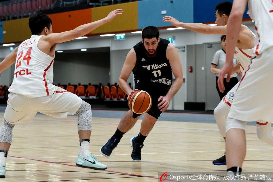 郭艾伦弯下腰重心压得极低，篮球仿佛黏在手中，他正面对防守球员准备启动突破，眼神中透露出捕捉战机的锐利，下一秒就将撕裂防守。