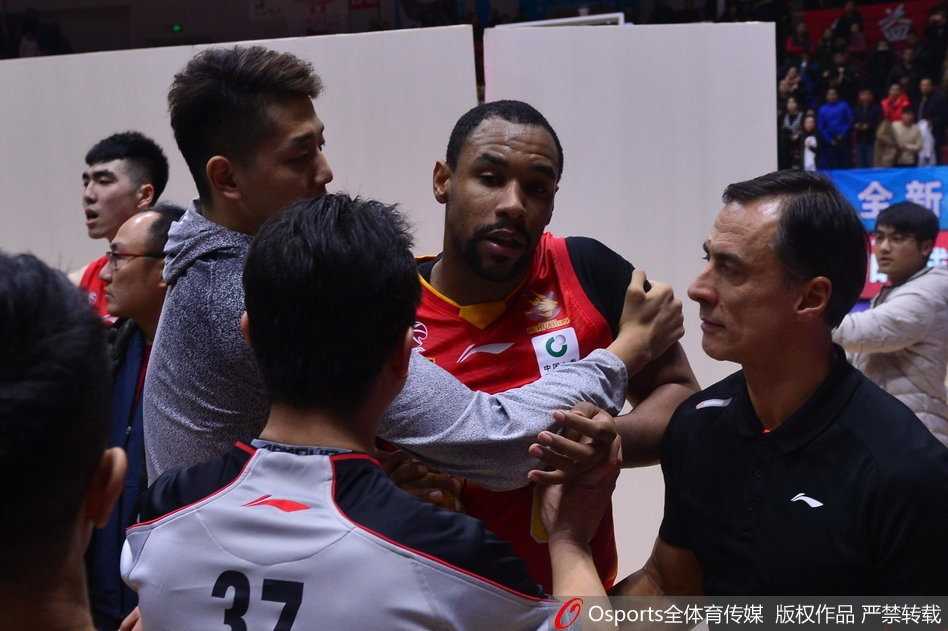 疆深赛后火爆冲突,外援萨林杰怒踹广告牌 就在一片混乱的人群脚下,一块白色的广告牌已经脱离了原本的位置,孤零零地躺在那里,边缘处有明显的凹陷和破损,成为了这场冲突的无声牺牲品。