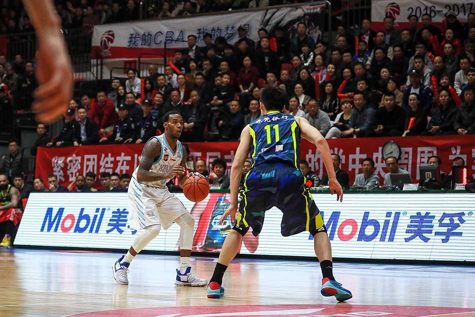 疆粤大战巅峰决,新王登基破魔咒——回顾2017CBA总决赛 新疆队外援布拉切篮下卡位后高举双臂忘情庆祝,身后是周琦与广东队员易建联、周鹏的激烈拼抢背景