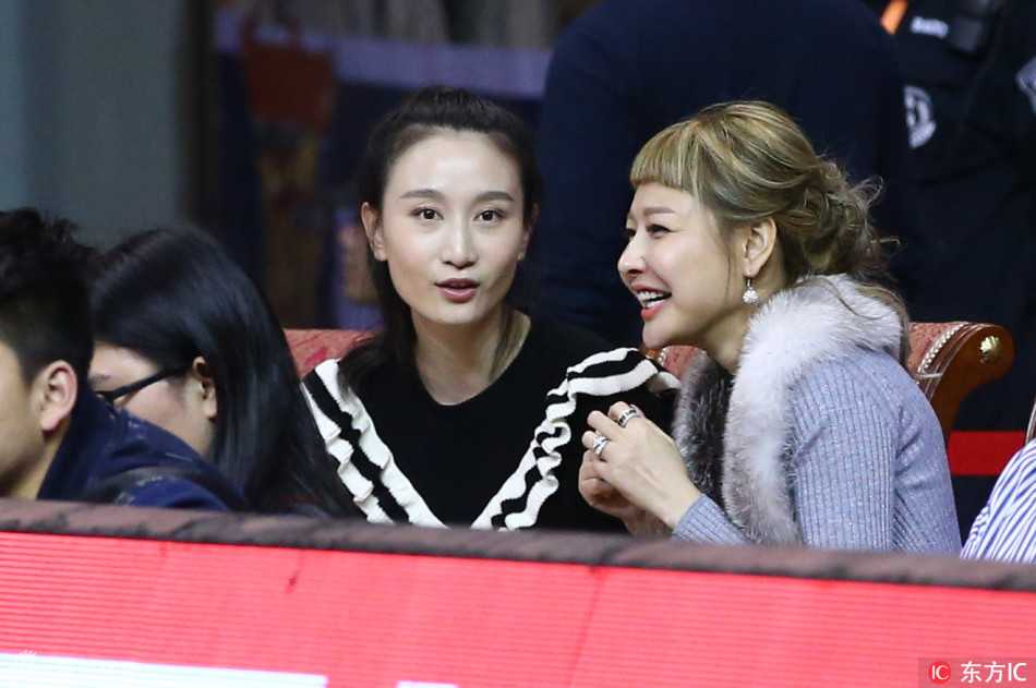 身着一袭黑色长裙的周琦女友，安静地坐在看台上，眼神中满是对男友的关切与骄傲，即使镜头拉远，也能感受到她那份独特的优雅气质。