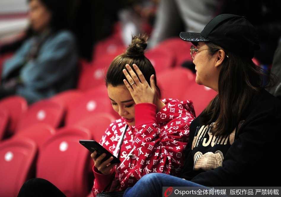 疆辽大战温情一幕:李根爱妻丸子头造型惊艳看台 李根妻子王星洋扎着清爽丸子头,侧颜轮廓精致,身穿休闲外套坐在看台上,目光越过人群投向赛场方向,眼神中充满期待。