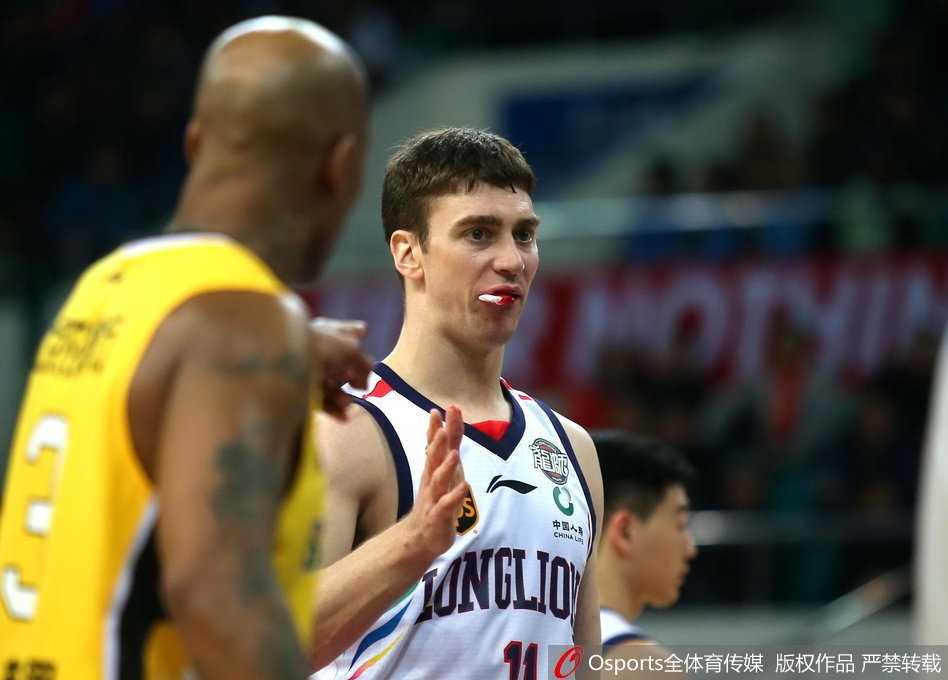 面对北控队员的贴身防守，汉斯布鲁弯腰运球突破，嘴角的血迹在灯光下格外醒目，对手的表情也显得凝重。