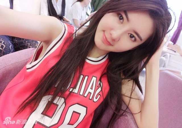 萌萌在篮球场上优雅站立，修长身材与篮网构成一幅动感画面，笑容比阳光还灿烂