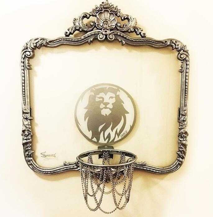 从篮板侧面看去，透明的材质让篮筐仿佛悬浮在空中，背景是模糊的绿树与天空，构成一幅动静结合的运动画卷。