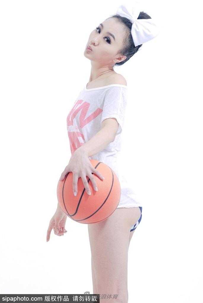 她身着一袭白色运动背心，修长的美腿在阳光下格外耀眼，手中的篮球仿佛也沾染了几分青春的气息。