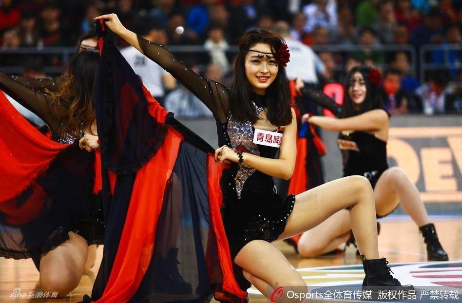 红色活力炫舞瞬间，舞者黑丝装束，疑似走光的惊险一刻，但甜美笑容不减，风情万种。