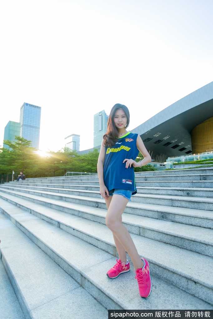 镜头捕捉到一位长发披肩的篮球宝贝回眸一笑的瞬间，眼神明亮而温柔，展现出赛场之外的甜美与灵动。