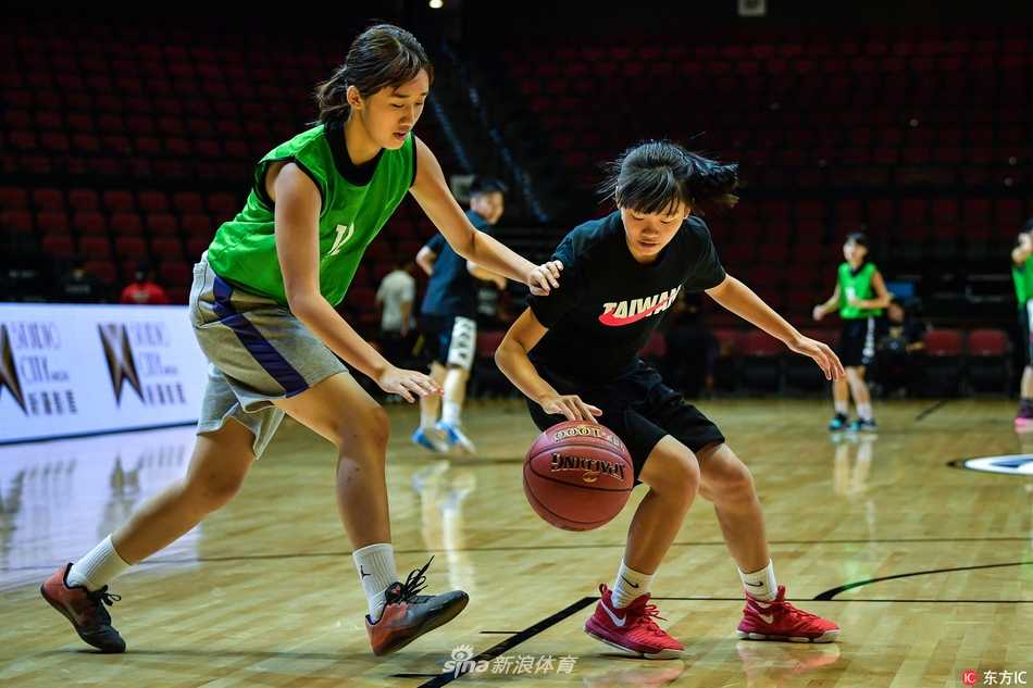 刚刚结束激烈比赛的运动员还没来得及擦去汗水，便亲切地弯腰与小球迷合影，孩子的眼神中充满了崇拜与喜悦，这一刻篮球架起了友谊的桥梁。