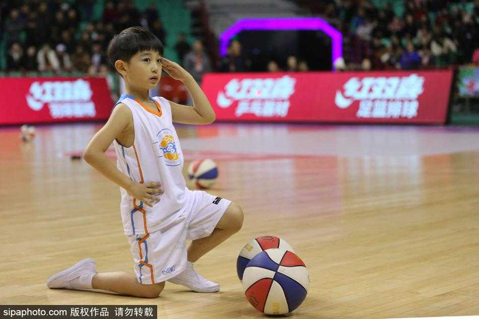 篮球萌娃燃爆CBA赛场,中场表演成冬日最暖风景 队形变换瞬间,萌娃们围成一个圈,中间一个小个子男孩高高抛起篮球,周围所有孩子仰头望球,脸上写满了期待与惊喜,画面充满了童趣和动感。